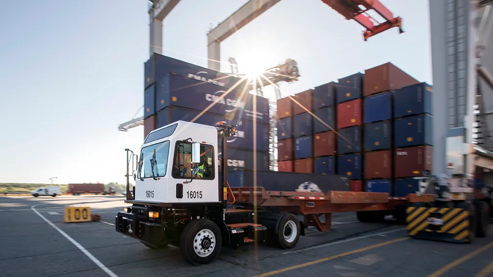 TICO spotter truck moving a container trailer through a shipping yard